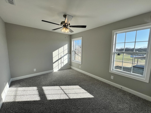 carpeted empty room featuring ceiling fan and a healthy amount of sunlight