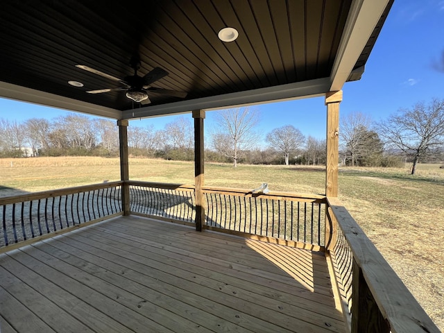 wooden deck with ceiling fan and a lawn