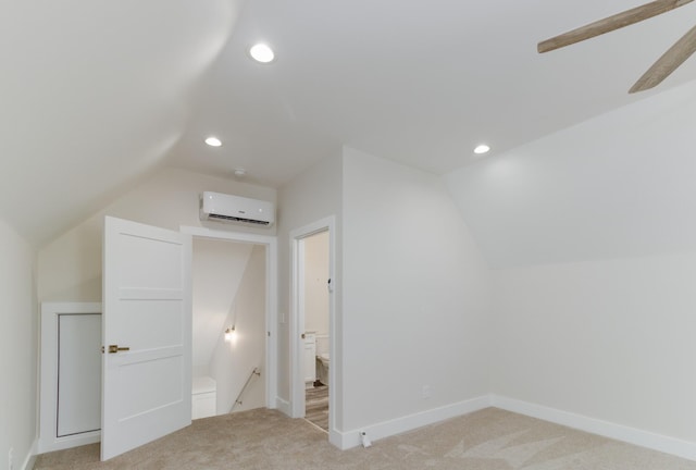 additional living space with a wall unit AC, lofted ceiling, and light colored carpet