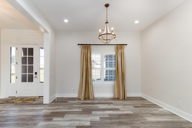 entryway with light wood-type flooring and an inviting chandelier