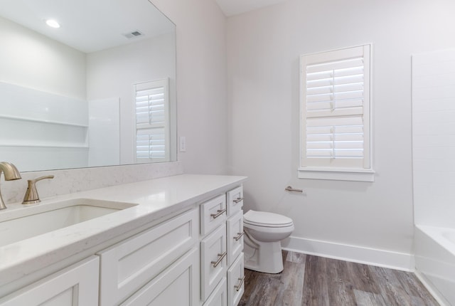 bathroom with toilet, vanity, and hardwood / wood-style flooring