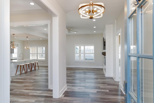 entrance foyer with ceiling fan with notable chandelier and dark hardwood / wood-style floors