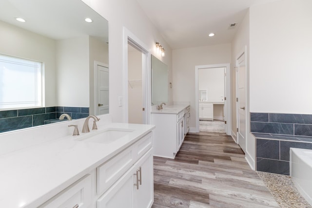 bathroom featuring a bath, wood-type flooring, and vanity