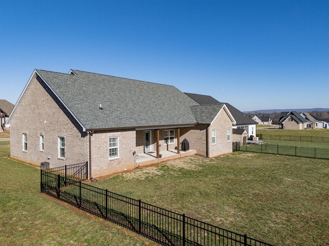 rear view of property featuring a patio area and a yard