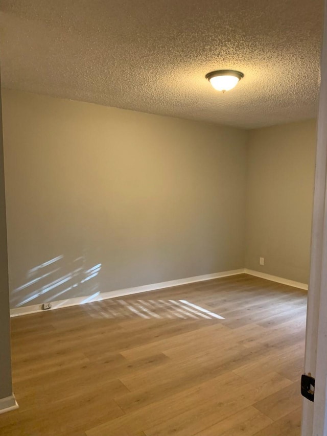 spare room with wood-type flooring and a textured ceiling