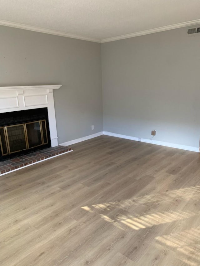 unfurnished living room featuring hardwood / wood-style flooring and crown molding