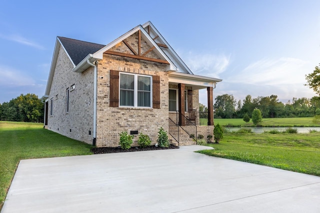 view of front facade featuring a front lawn, a water view, and covered porch