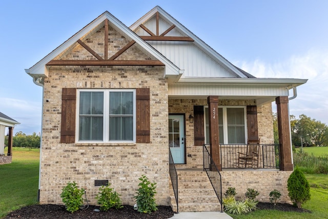 view of front of home featuring covered porch and a front lawn