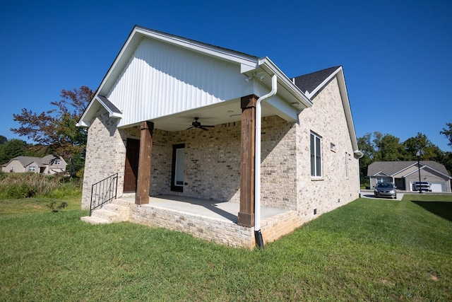 rear view of property with ceiling fan and a yard