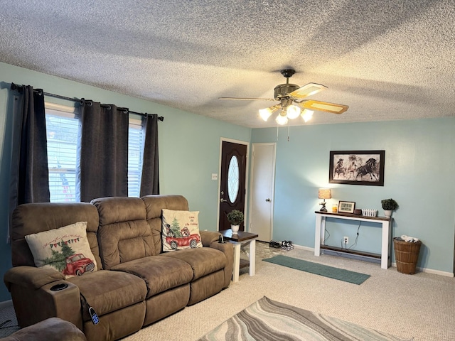 living room featuring carpet, ceiling fan, and a textured ceiling