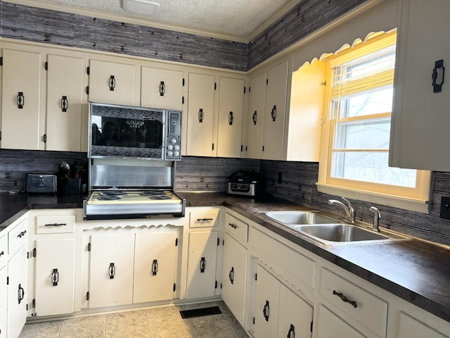 kitchen featuring decorative backsplash, sink, a textured ceiling, and gas stovetop