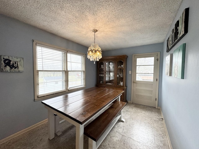 dining space with a notable chandelier, a textured ceiling, and a wealth of natural light