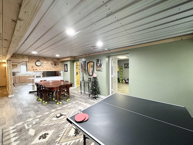 recreation room featuring light hardwood / wood-style floors, wood ceiling, and wooden walls