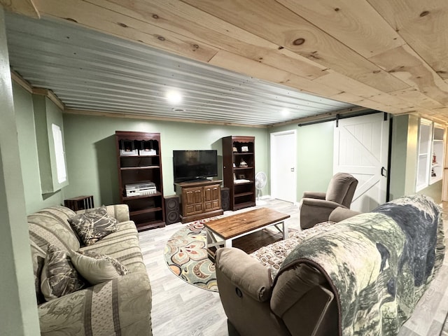 living room featuring a barn door, light hardwood / wood-style flooring, and wooden ceiling
