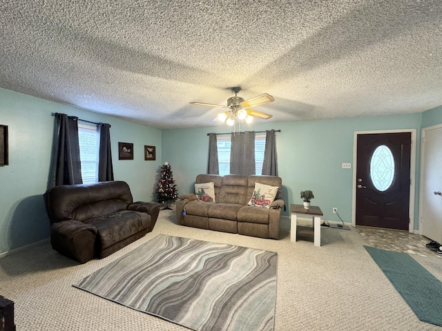 living room featuring carpet flooring, ceiling fan, and a textured ceiling