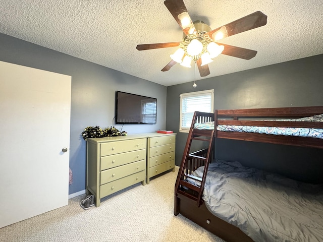 carpeted bedroom featuring a textured ceiling and ceiling fan