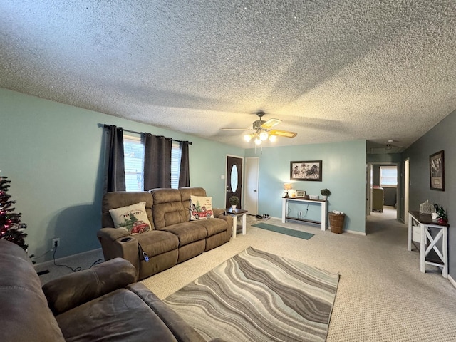 carpeted living room with a textured ceiling, ceiling fan, and a healthy amount of sunlight
