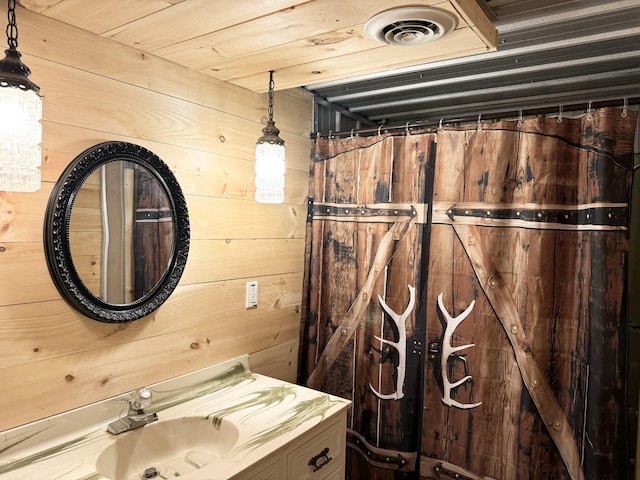bathroom featuring vanity and wooden walls