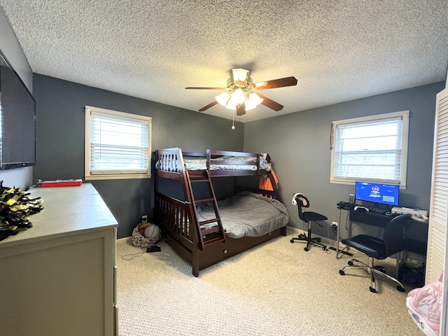 bedroom featuring carpet flooring, ceiling fan, a textured ceiling, and multiple windows