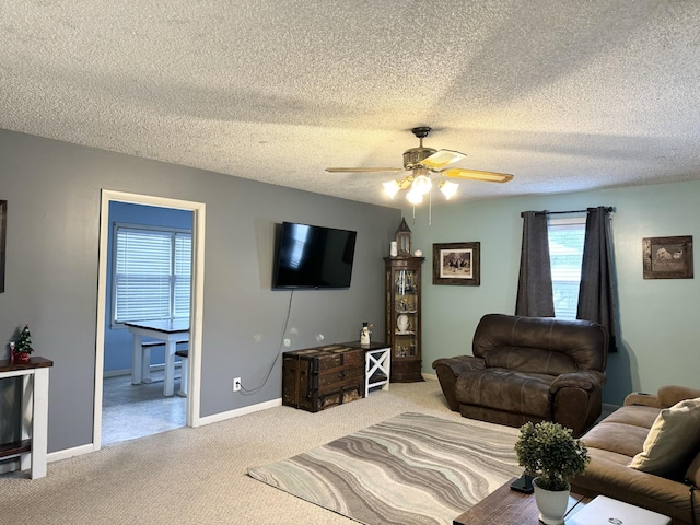 living room featuring carpet flooring, a textured ceiling, and ceiling fan