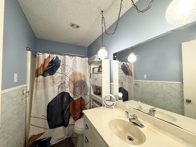 bathroom with vanity, a textured ceiling, and toilet
