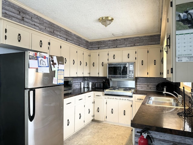 kitchen with decorative backsplash, sink, stainless steel appliances, and a textured ceiling