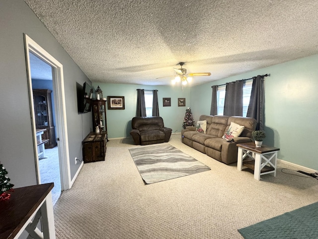 living room featuring ceiling fan, carpet floors, and a textured ceiling