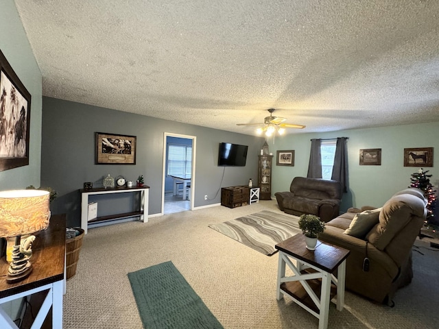 living room featuring carpet, ceiling fan, and a textured ceiling