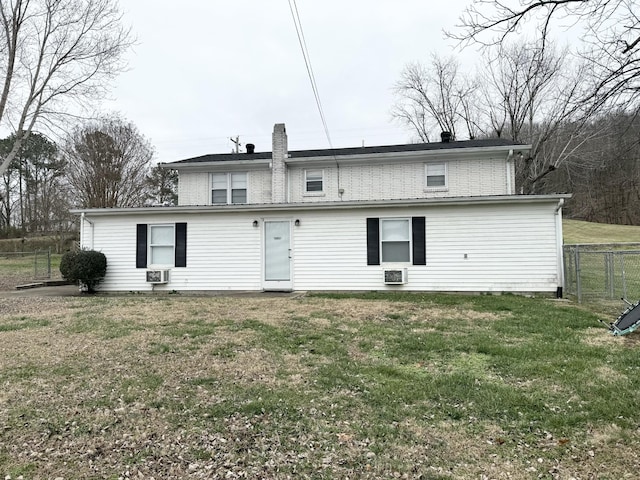 rear view of house featuring cooling unit and a yard