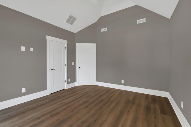 empty room featuring lofted ceiling and dark wood-type flooring