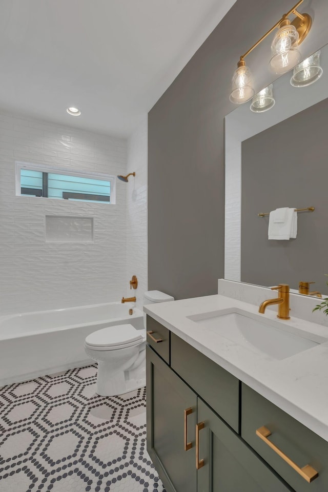 full bathroom featuring toilet, vanity, and tiled shower / bath