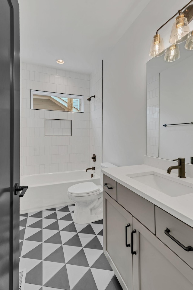 full bathroom featuring vanity, tiled shower / bath combo, and toilet