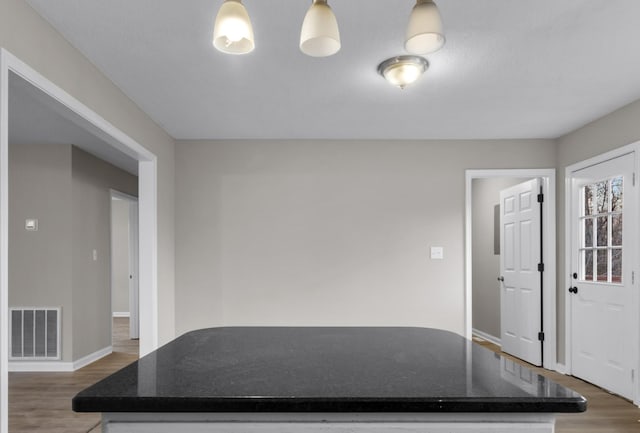 interior space featuring pendant lighting and dark wood-type flooring