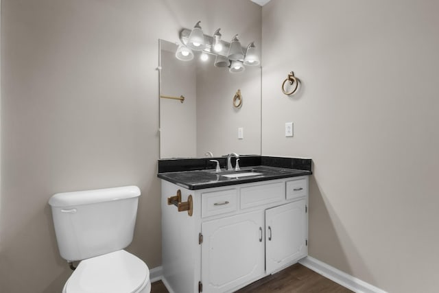 bathroom with vanity, toilet, and wood-type flooring