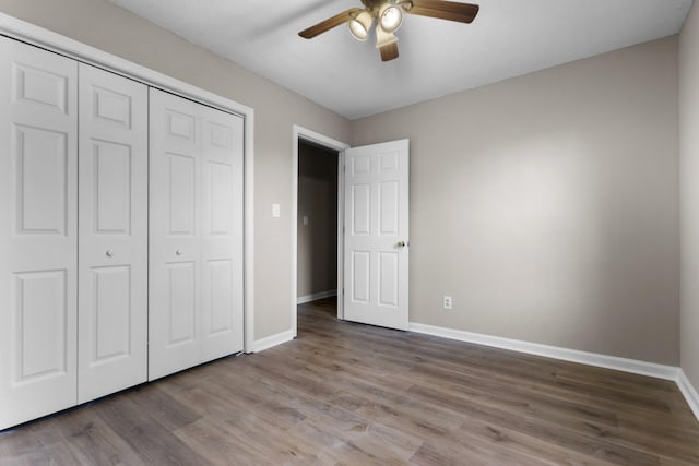 unfurnished bedroom with wood-type flooring, a closet, and ceiling fan