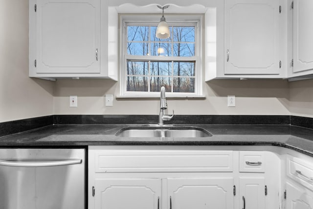 kitchen featuring white cabinetry, hanging light fixtures, stainless steel dishwasher, and sink