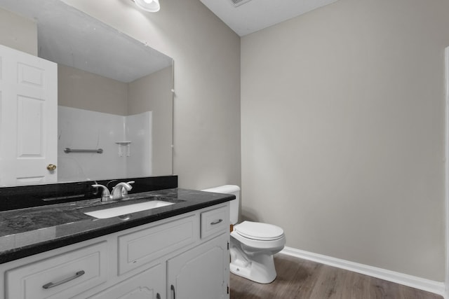 bathroom featuring hardwood / wood-style floors, vanity, toilet, and walk in shower