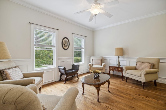 living area featuring ceiling fan, ornamental molding, and light hardwood / wood-style flooring