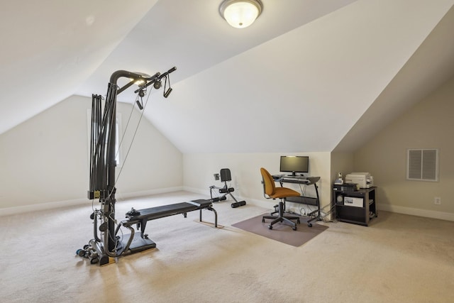 exercise room featuring vaulted ceiling and light carpet