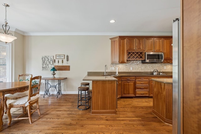 kitchen featuring pendant lighting, sink, dark hardwood / wood-style flooring, and a kitchen bar