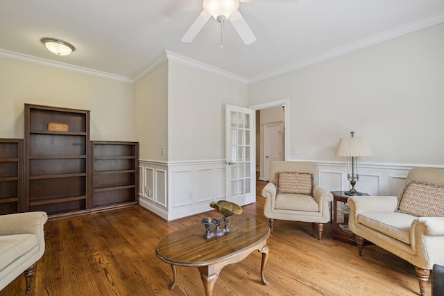 living area featuring hardwood / wood-style floors, crown molding, and ceiling fan