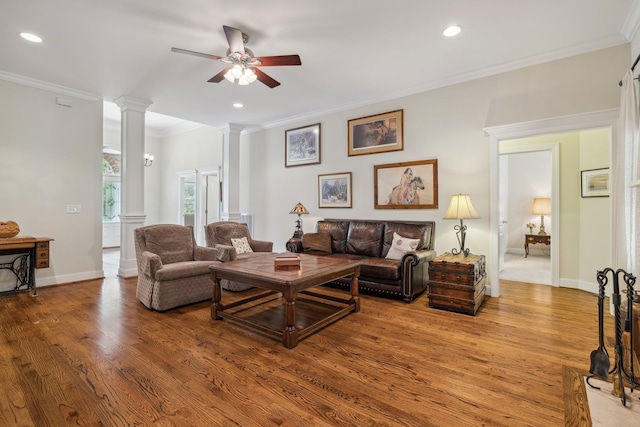 living room with decorative columns, crown molding, hardwood / wood-style flooring, and ceiling fan