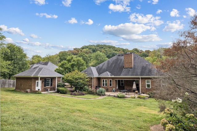 rear view of house featuring a patio and a lawn