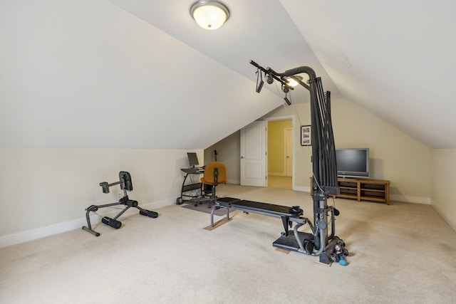 exercise room featuring vaulted ceiling and carpet