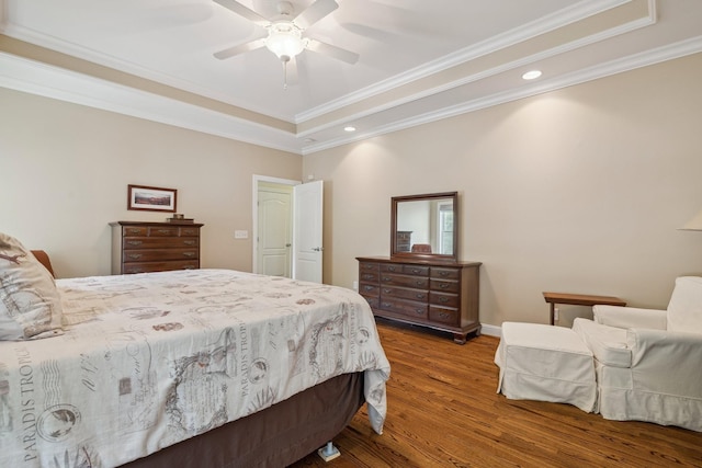 bedroom featuring crown molding, hardwood / wood-style flooring, a tray ceiling, and ceiling fan