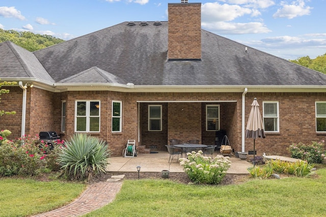 rear view of house featuring a lawn and a patio area