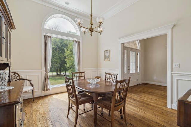 dining room with a notable chandelier, ornamental molding, and light hardwood / wood-style floors