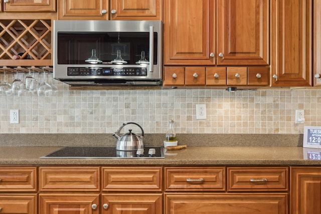 kitchen with black electric cooktop and decorative backsplash