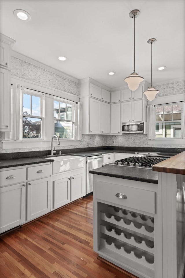 kitchen featuring sink, stainless steel appliances, dark hardwood / wood-style flooring, butcher block countertops, and white cabinets