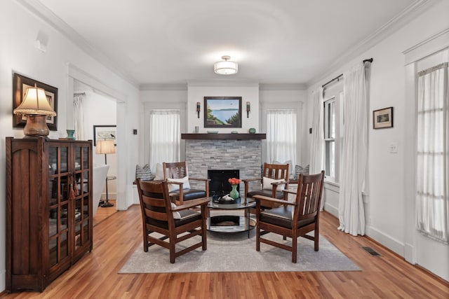 sitting room featuring hardwood / wood-style flooring, crown molding, and a fireplace